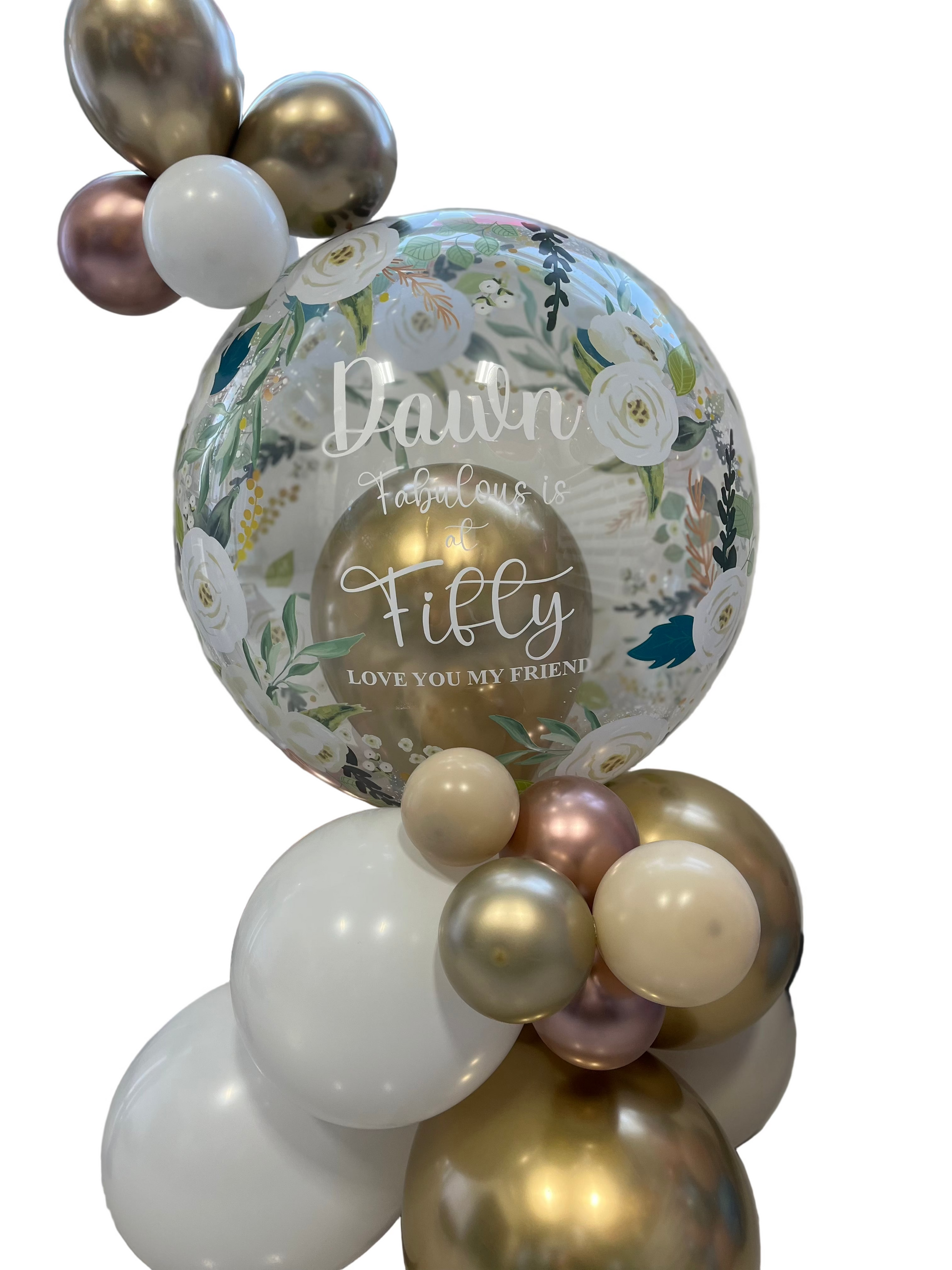 Decorative balloon arrangement with a floral balloon and text, featuring gold, white, and pink balloons.