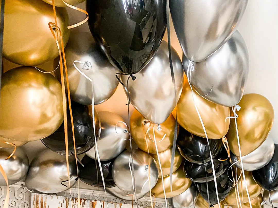 Decorative arrangement of gold, black, and silver balloon.
